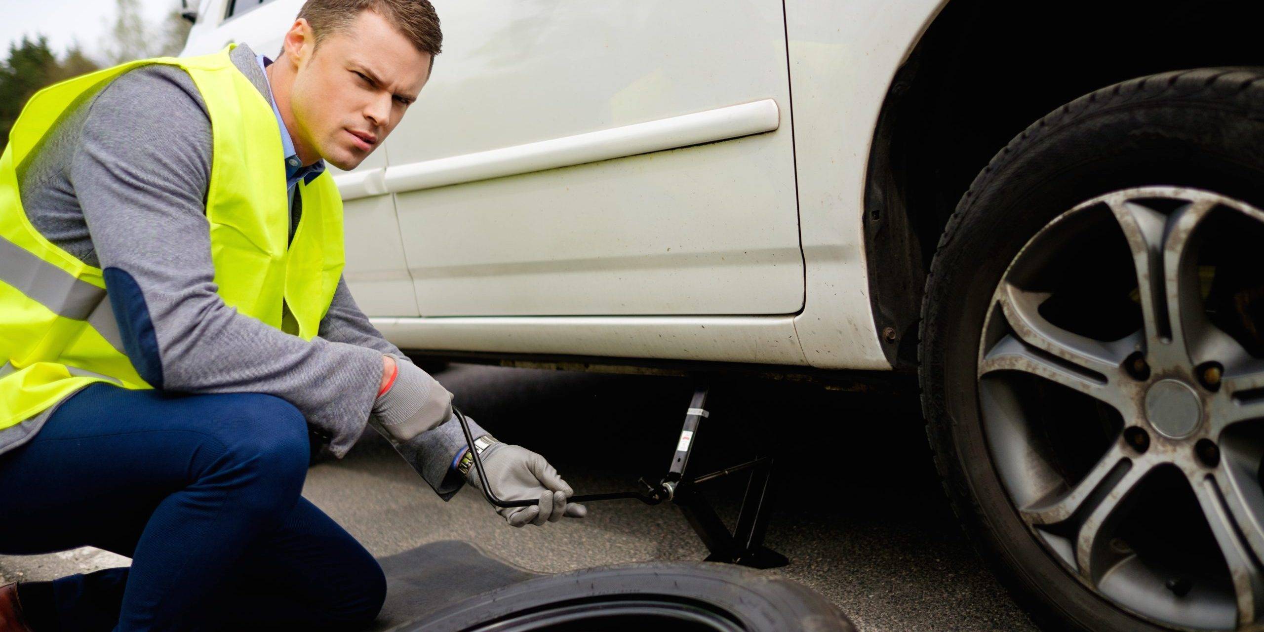 Man Changing Wheel On A Roadside Man Changing Wheel On A Roadside
